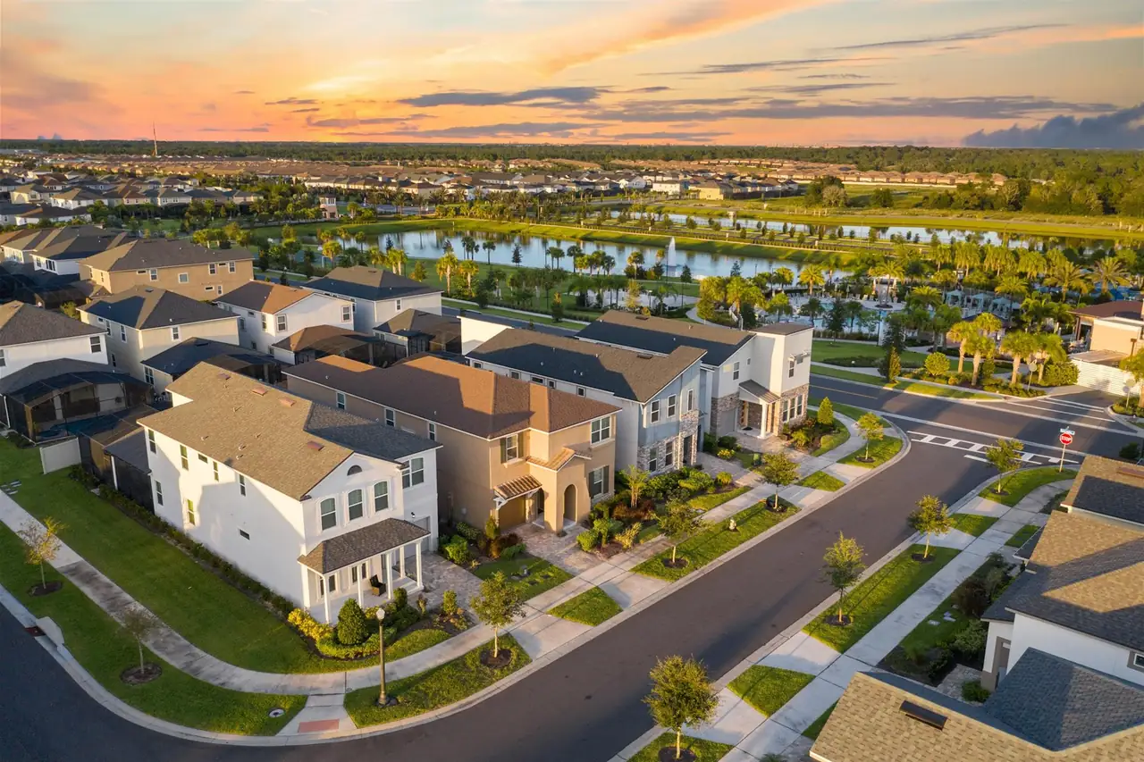 Vista aérea de casas de condomínio em Orlando ao entardecer, com lago e palmeiras